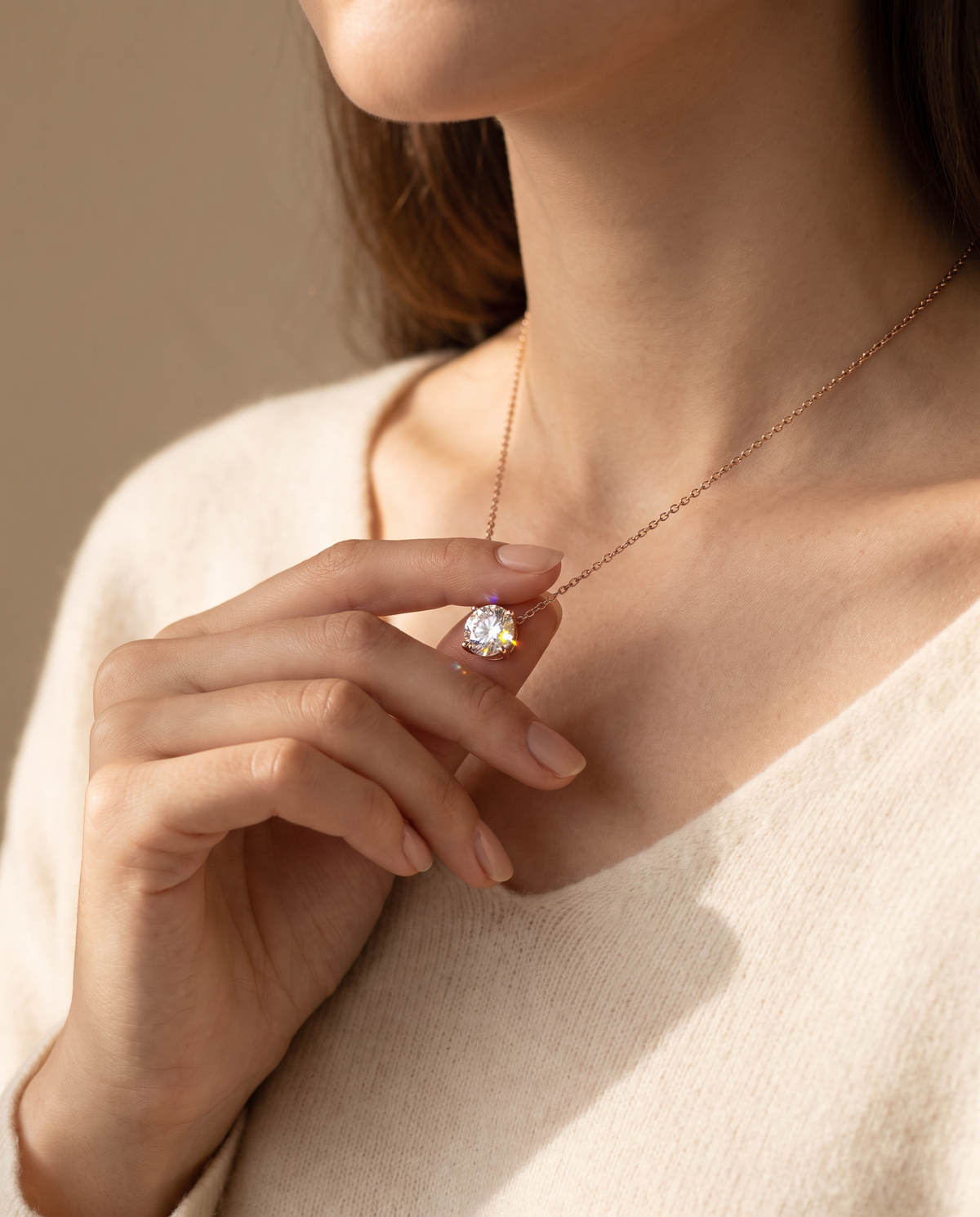 Collier Solitaire Éclat porté, la main sur le pendentif